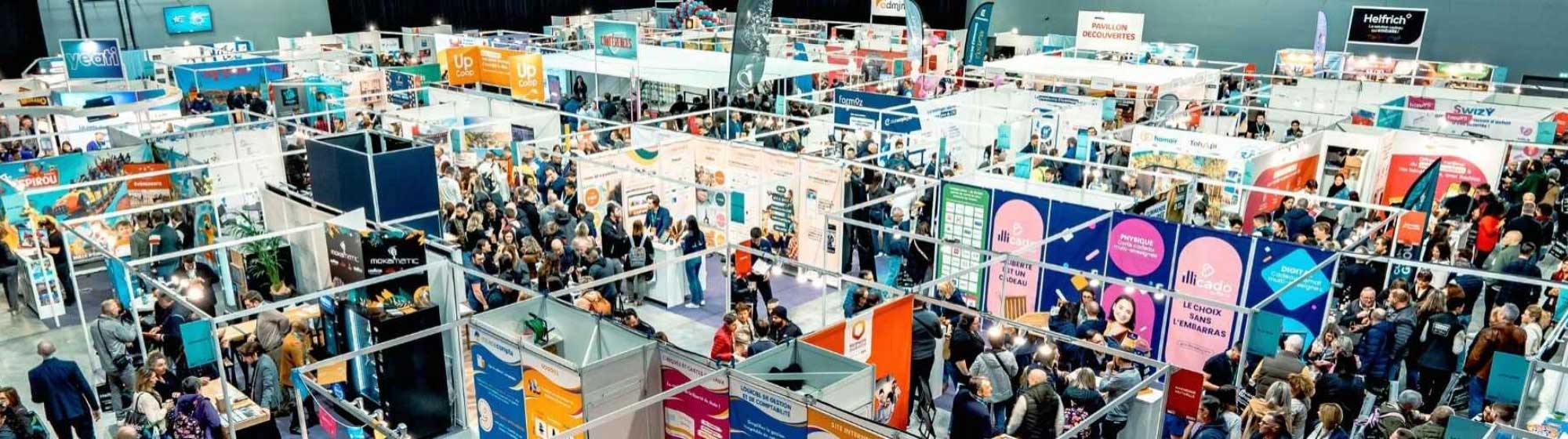 Photographie d'un salon professionnel, avec foule dans les allées et de nombreux stands